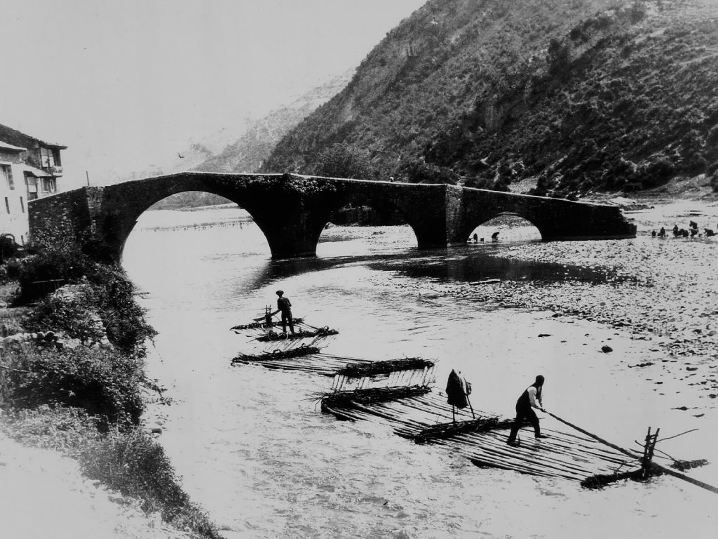 Gancheros transportando troncos por flotación en un río, oficio antiguo desaparecido